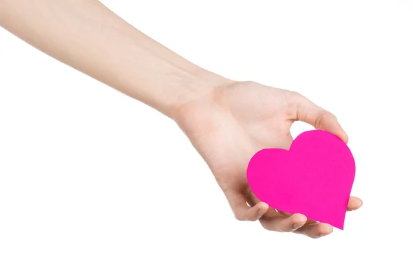 Valentine's Day and love theme: hand holding a pink heart isolated on a white background in studio — Stock Photo, Image