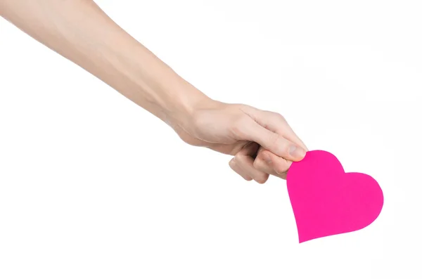 Valentine's Day and love theme: hand holding a pink heart isolated on a white background in studio — Stock Photo, Image