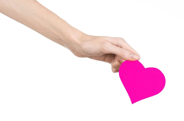 Valentine's Day and love theme: hand holding a pink heart isolated on a white background in studio — Stock Photo, Image