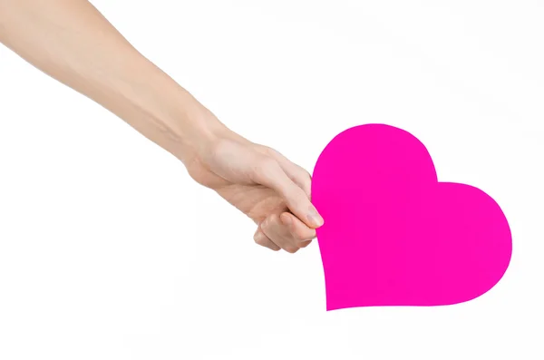 Valentine's Day and love theme: hand holding a pink heart isolated on a white background in studio — Stock Photo, Image