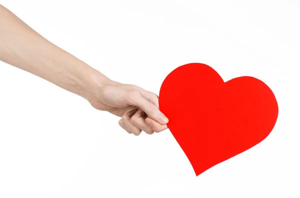 Valentýna a láska téma: ruka drží červené srdce izolovaných na bílém pozadí v studio — Stock fotografie