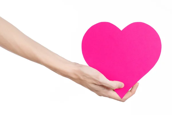 Valentine's Day and love theme: hand holding a pink heart isolated on a white background in studio — Stock Photo, Image