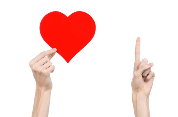Alla hjärtans dag och kärlek tema: hand som håller ett rött hjärta isolerad på en vit bakgrund i studio — Stockfoto