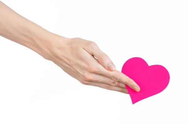 Valentine's Day and love theme: hand holding a pink heart isolated on a white background in studio — Stock Photo, Image