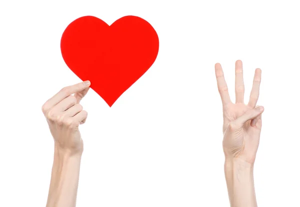 Walentynki i love theme: ręka trzyma czerwonym sercem na białym tle na białym tle w studio — Zdjęcie stockowe