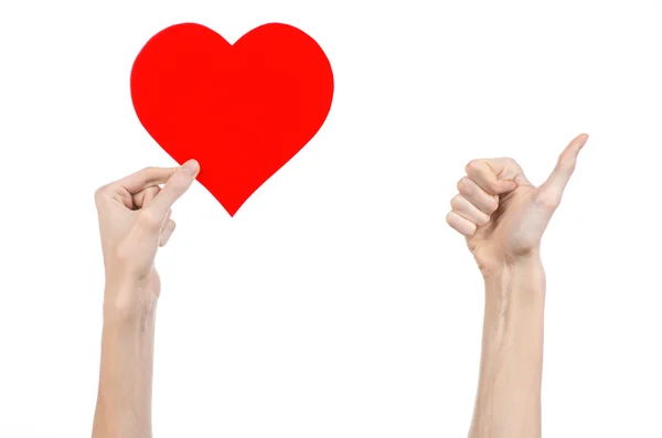 Valentine's Day and love theme: hand holding a red heart isolated on a white background in studio — Stock Photo, Image