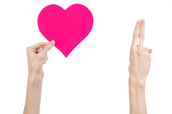 San Valentino e il tema dell'amore: mano che tiene un cuore rosa isolato su sfondo bianco in studio — Foto Stock