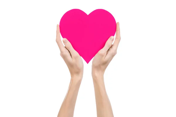 Tema Día de San Valentín y amor: la mano sosteniendo un corazón rosa aislado sobre un fondo blanco en el estudio — Foto de Stock
