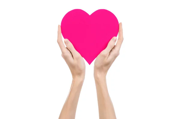 Valentine's Day and love theme: hand holding a pink heart isolated on a white background in studio — Stock Photo, Image