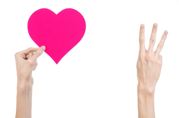 Tema Día de San Valentín y amor: la mano sosteniendo un corazón rosa aislado sobre un fondo blanco en el estudio —  Fotos de Stock