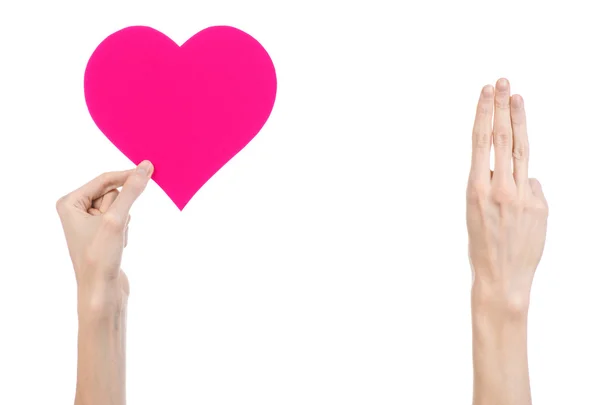 Tema Día de San Valentín y amor: la mano sosteniendo un corazón rosa aislado sobre un fondo blanco en el estudio — Foto de Stock