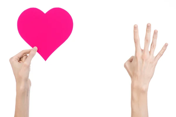 Valentine's Day and love theme: hand holding a pink heart isolated on a white background in studio — Stock Photo, Image