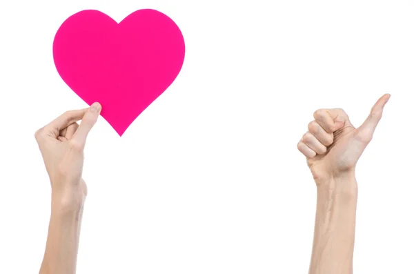 Tema Día de San Valentín y amor: la mano sosteniendo un corazón rosa aislado sobre un fondo blanco en el estudio — Foto de Stock