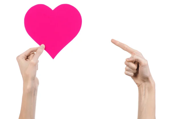 Valentine's Day and love theme: hand holding a pink heart isolated on a white background in studio — Stock Photo, Image