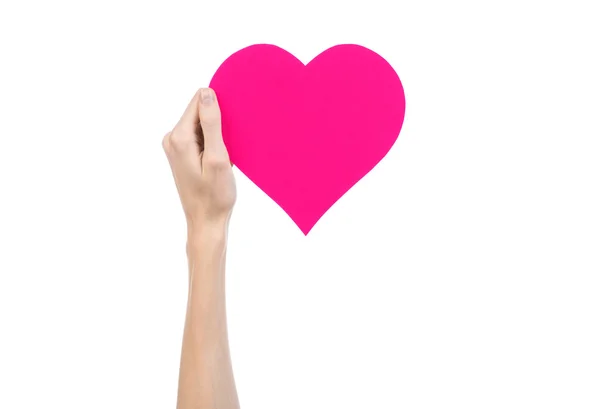 Valentine's Day and love theme: hand holding a pink heart isolated on a white background in studio — Stock Photo, Image