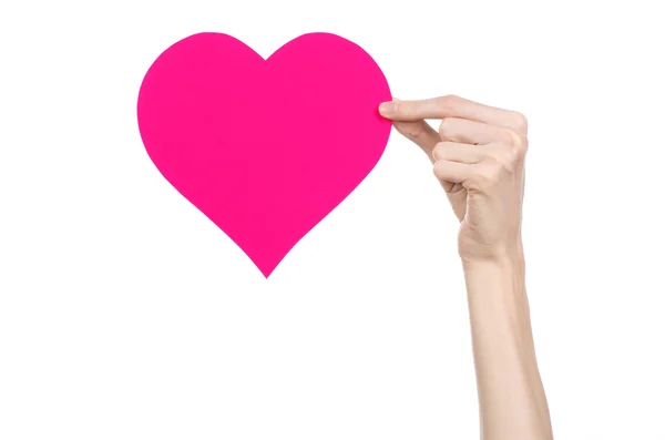 Valentine's Day and love theme: hand holding a pink heart isolated on a white background in studio — Stock Photo, Image