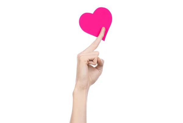 Valentine's Day and love theme: hand holding a pink heart isolated on a white background in studio — Stock Photo, Image