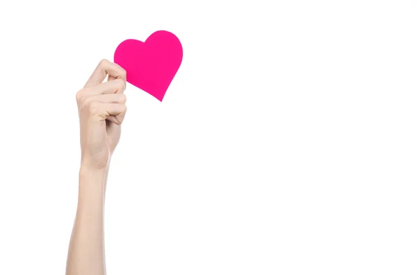 Valentine's Day and love theme: hand holding a pink heart isolated on a white background in studio — Stock Photo, Image