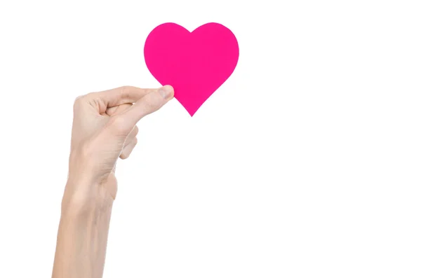 Tema Día de San Valentín y amor: la mano sosteniendo un corazón rosa aislado sobre un fondo blanco en el estudio — Foto de Stock