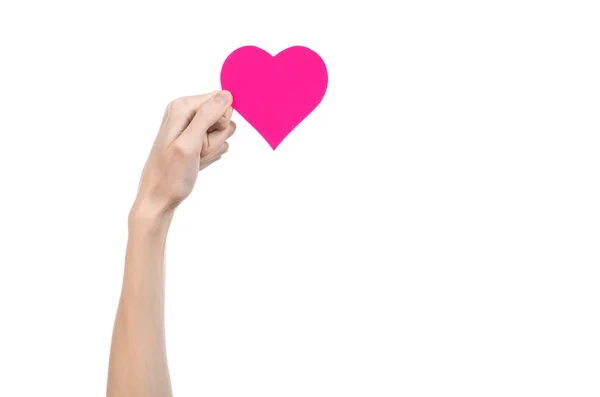 Valentine's Day and love theme: hand holding a pink heart isolated on a white background in studio — Stock Photo, Image