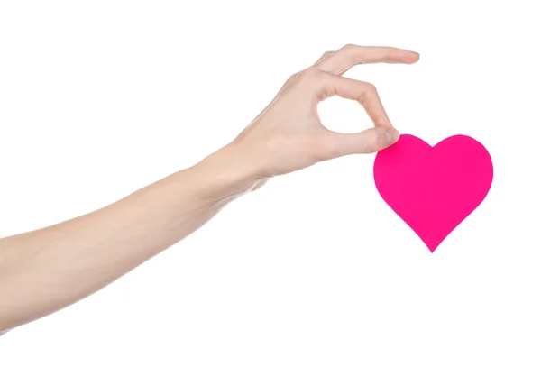 Tema Día de San Valentín y amor: la mano sosteniendo un corazón rosa aislado sobre un fondo blanco en el estudio — Foto de Stock