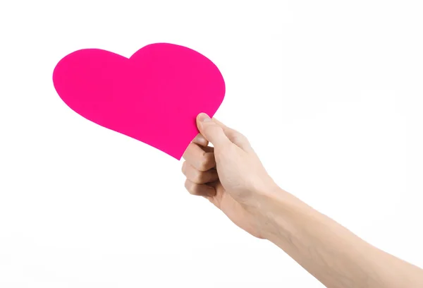 Sevgililer günü ve aşk şarkısı: Studio beyaz bir arka plan üzerinde izole bir pembe kalp tutan el — Stok fotoğraf