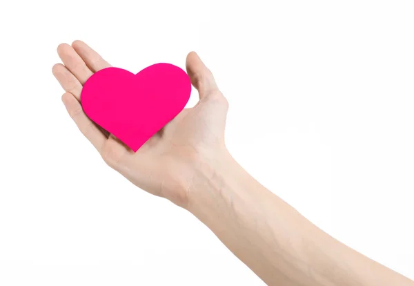 Tema Día de San Valentín y amor: la mano sosteniendo un corazón rosa aislado sobre un fondo blanco en el estudio —  Fotos de Stock