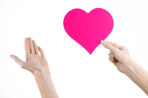 Valentine's Day and love theme: hand holding a pink heart isolated on a white background in studio — Stock Photo, Image