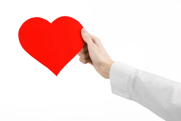 Καρδιακές παθήσεις και υγεία θέμα: χέρι γιατρός σε ένα λευκό πουκάμισο, κρατώντας μια κάρτα με τη μορφή μια κόκκινη καρδιά απομονωθεί σε λευκό φόντο σε στούντιο — Φωτογραφία Αρχείου