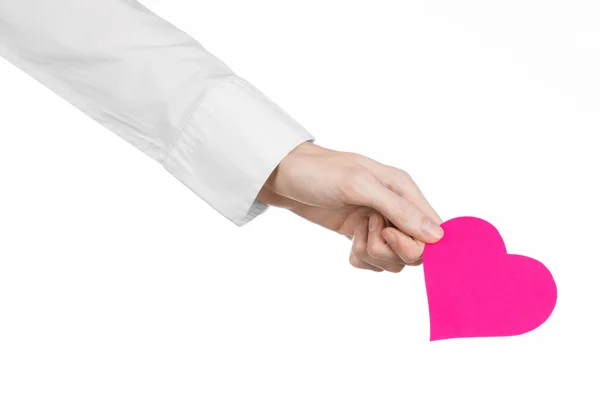 Tema de Enfermedades del Corazón y Salud: Médico de mano con una camisa blanca sosteniendo una tarjeta en forma de corazón rosa aislado sobre un fondo blanco en el estudio —  Fotos de Stock