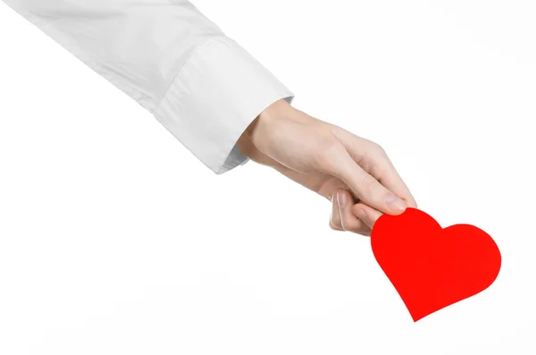 Tema de Enfermedades del Corazón y Salud: Médico de mano con una camisa blanca sosteniendo una tarjeta en forma de corazón rojo aislado sobre un fondo blanco en el estudio — Foto de Stock