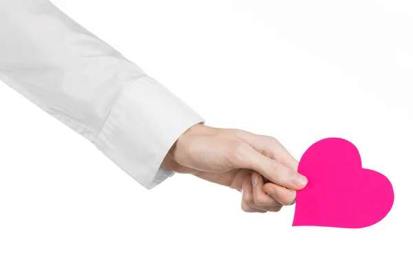 Doença cardíaca e saúde Tópico: médico de mão em uma camisa branca segurando um cartão na forma de um coração rosa isolado em um fundo branco no estúdio — Fotografia de Stock