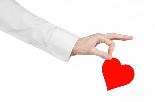 Tema de Enfermedades del Corazón y Salud: Médico de mano con una camisa blanca sosteniendo una tarjeta en forma de corazón rojo aislado sobre un fondo blanco en el estudio — Foto de Stock