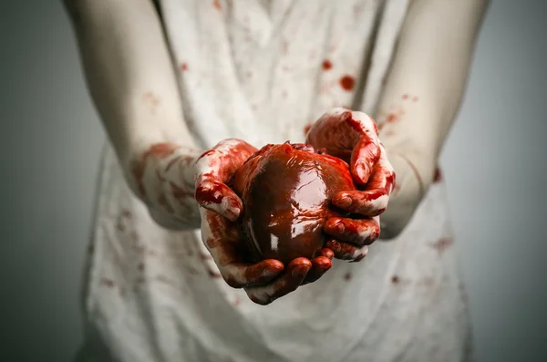 Bloody Halloween tema: assassino louco mantém as mãos sangrentas rasgado sangrento coração humano e experimentando depressão e dor — Fotografia de Stock