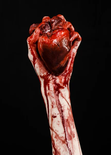 Kan ve Halloween Tema: kanlı kadar kötü bir elle insan kalbi Studio siyah arka plan üzerine izole kanama yırtık tutun