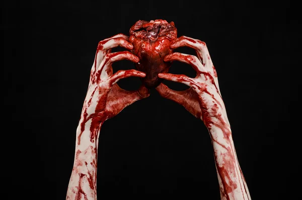 Тема Blood and Halloween: жахлива кривава рука тримає рвану кров людського серця ізольовано на чорному тлі в студії — стокове фото