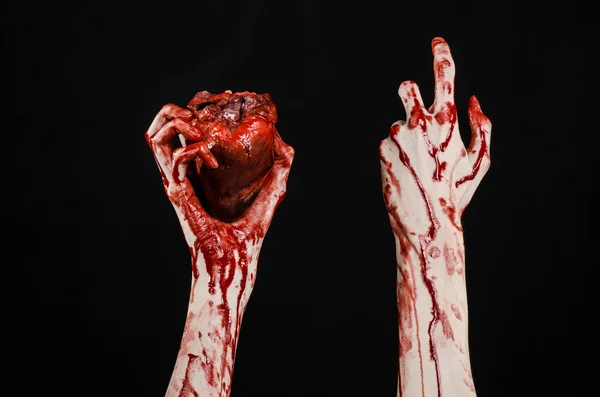 Sangre y Halloween tema: terrible sangrienta mano sostener desgarrado corazón humano sangrante aislado sobre fondo negro en el estudio — Foto de Stock