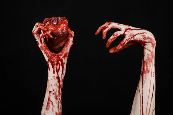 Blut und Halloween-Thema: schrecklich blutige Hand hält abgerissenes blutendes Menschenherz isoliert auf schwarzem Hintergrund im Studio — Stockfoto