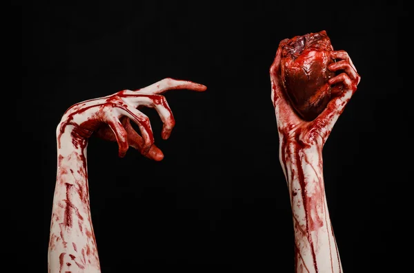 血液和万圣节主题: 可怕的血腥手举行撕裂出血孤立在工作室中的黑色背景上的人类心 — 图库照片