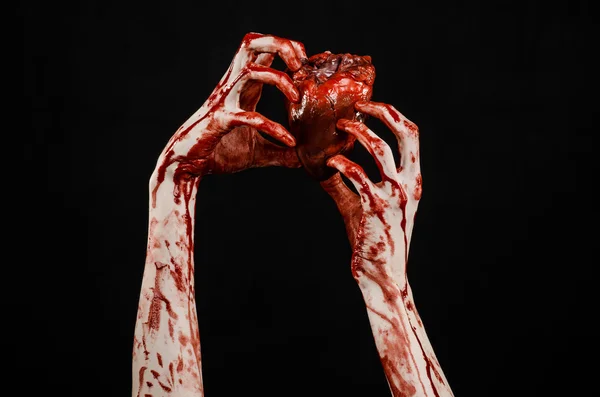 Sangre y Halloween tema: terrible sangrienta mano sostener desgarrado corazón humano sangrante aislado sobre fondo negro en el estudio — Foto de Stock