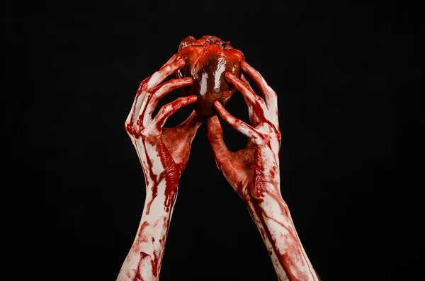 Blut und Halloween-Thema: schrecklich blutige Hand hält abgerissenes blutendes Menschenherz isoliert auf schwarzem Hintergrund im Studio — Stockfoto