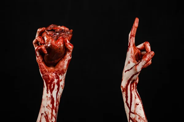 Blut und Halloween-Thema: schrecklich blutige Hand hält abgerissenes blutendes Menschenherz isoliert auf schwarzem Hintergrund im Studio — Stockfoto