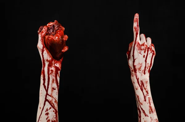 Sangre y Halloween tema: terrible sangrienta mano sostener desgarrado corazón humano sangrante aislado sobre fondo negro en el estudio — Foto de Stock