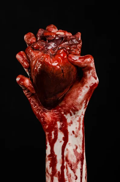 Blood and Halloween theme: terrible bloody hand hold torn bleeding human heart isolated on black background in studio — Stock Photo, Image