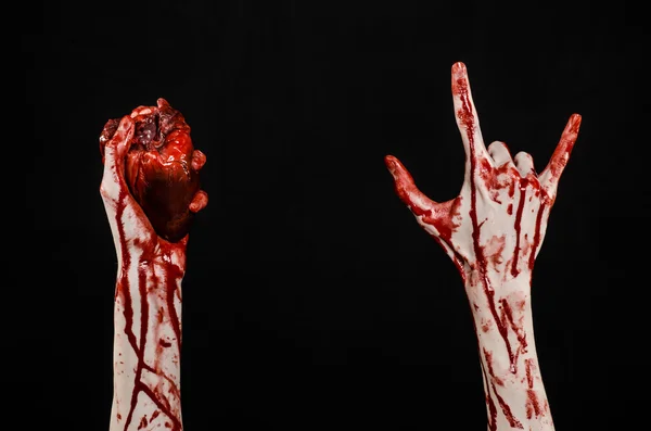 Sangre y Halloween tema: terrible sangrienta mano sostener desgarrado corazón humano sangrante aislado sobre fondo negro en el estudio — Foto de Stock