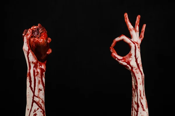 Blood and Halloween theme: terrible bloody hand hold torn bleeding human heart isolated on black background in studio — Stock Photo, Image