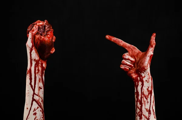 Sangre y Halloween tema: terrible sangrienta mano sostener desgarrado corazón humano sangrante aislado sobre fondo negro en el estudio — Foto de Stock