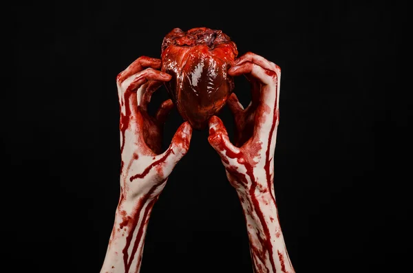 Blood and Halloween theme: terrible bloody hand hold torn bleeding human heart isolated on black background in studio — Stock Photo, Image