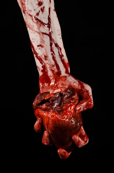 Blood and Halloween theme: terrible bloody hand hold torn bleeding human heart isolated on black background in studio — Stock Photo, Image