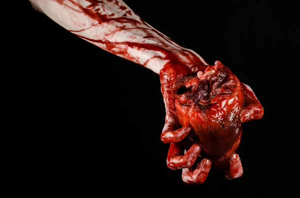 Sangre y Halloween tema: terrible sangrienta mano sostener desgarrado corazón humano sangrante aislado sobre fondo negro en el estudio — Foto de Stock